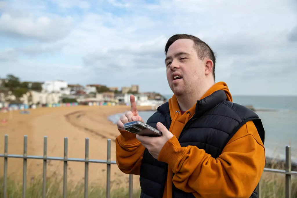 Disabled man with down syndrome making a phone call to support worker